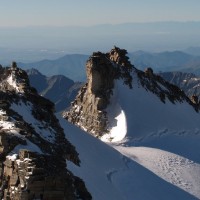 Lo sguardo si estende sugli inconfondibili bastioni del Gran Paradiso